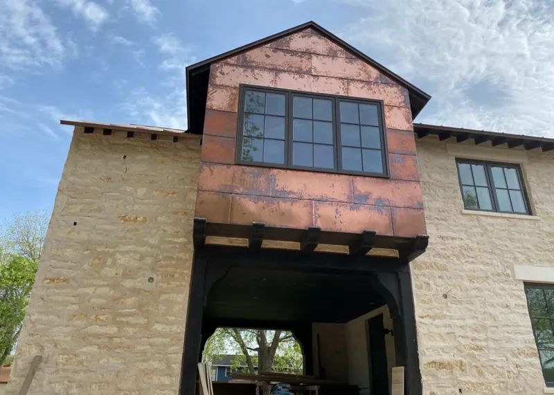 Copper metal panel facade on a stone building for Roof Repair in Catoosa