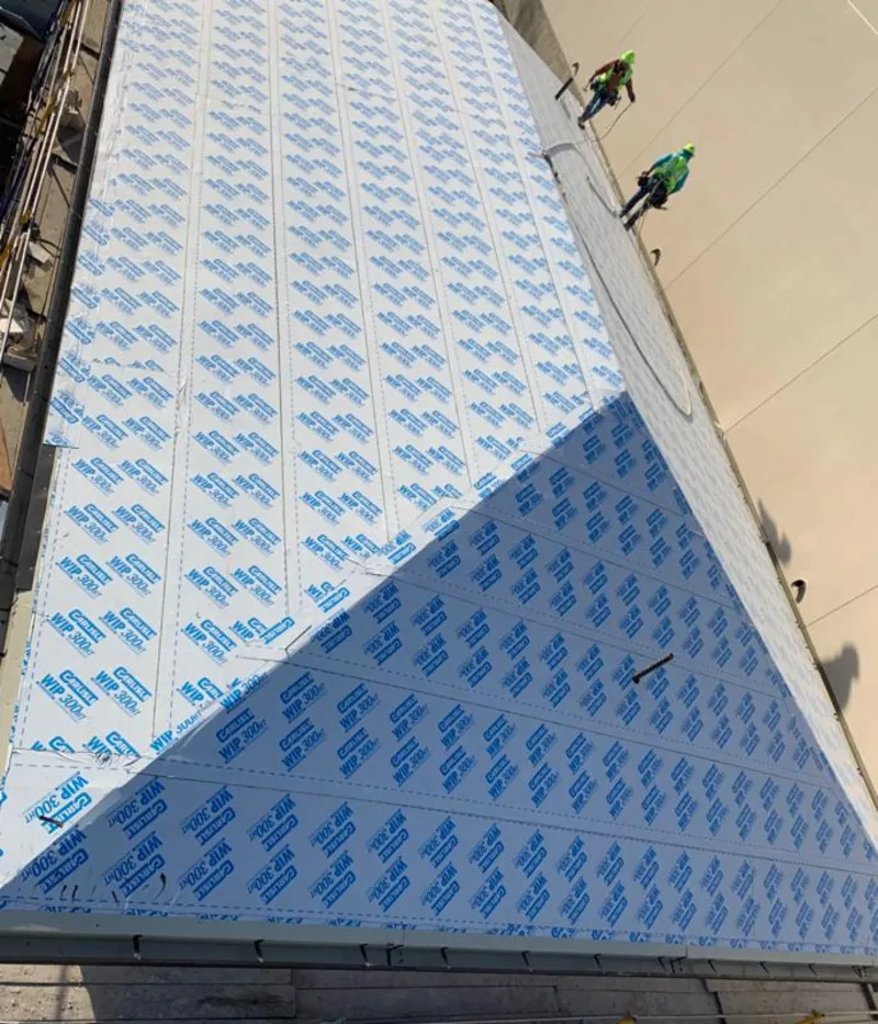 Professional roofers installing underlayment on a metal roof in Catoosa